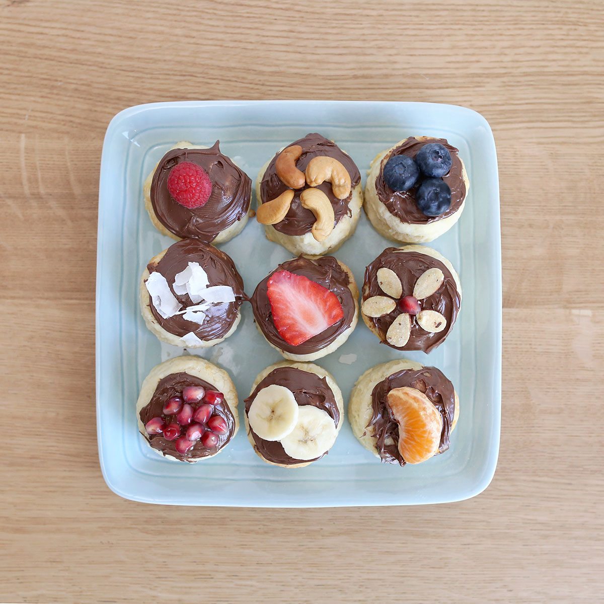Plate of biscuits with fruit and Nutella on top