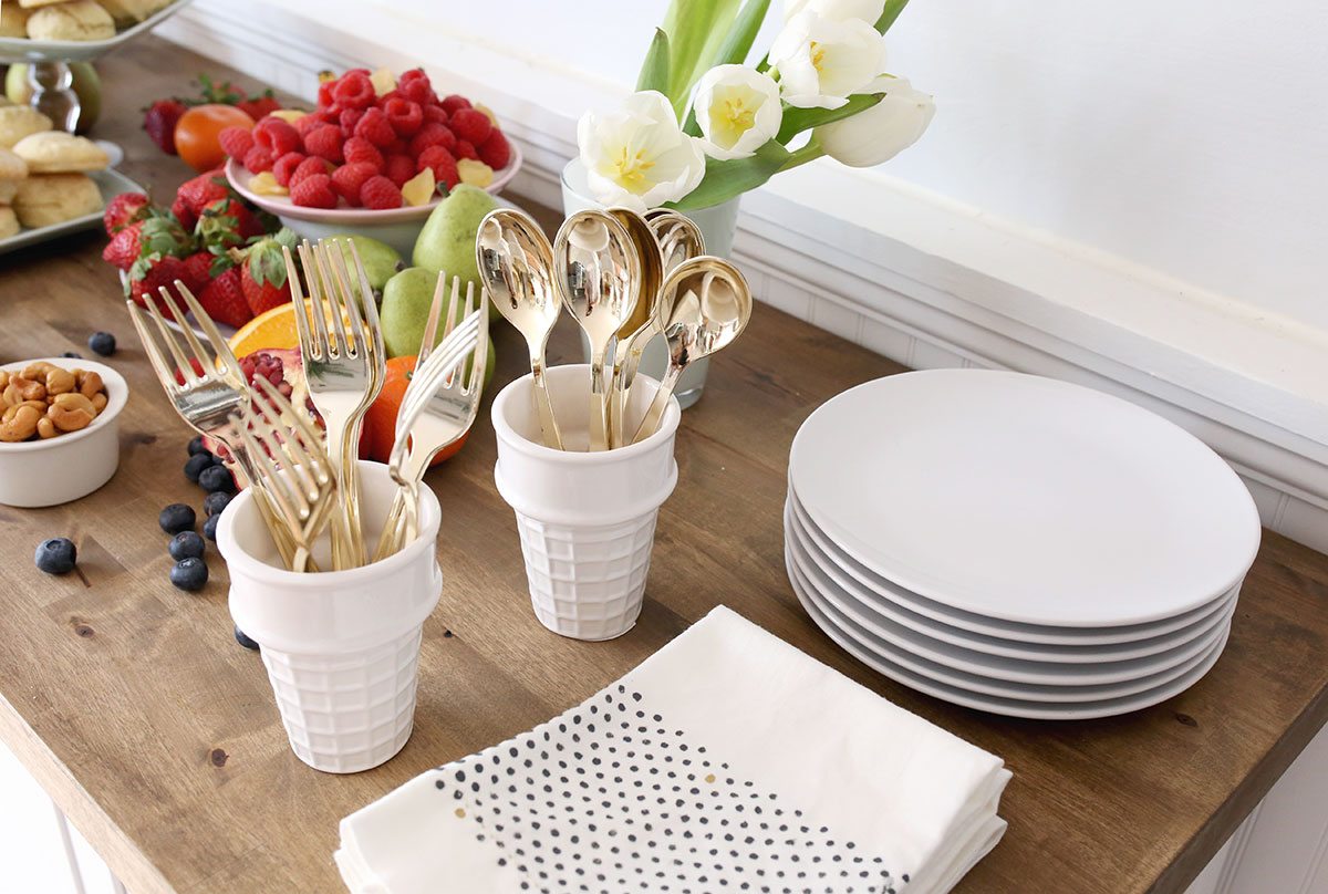 Plates, napkins, and silverware on a breakfast buffet