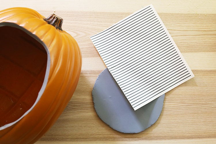 Cutting out vinyl lines with a Cricut machine to apply to foam insert for diorama pumpkin
