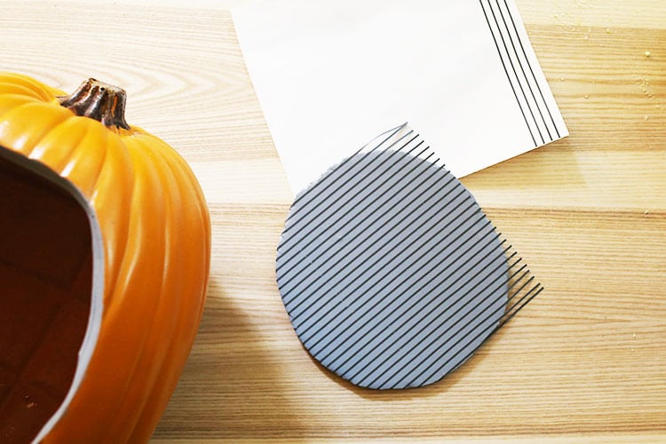 Applying adhesive vinyl lines to foam circle for Halloween pumpkin