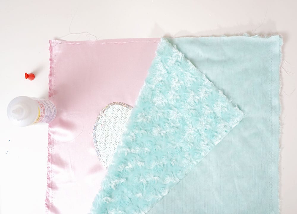 Turquoise faux fur fabric on top of reversible sequin fabric heart and pink satin to make a mermaid sequin pillow