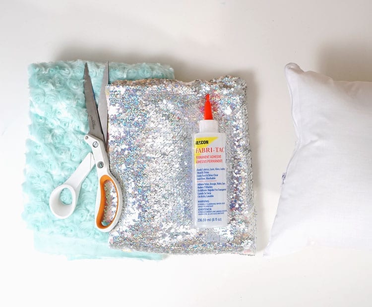 Fabric, sewing scissors, Beacon Adhesives Fabri-Tac glue, and pillow insert for magic sequin pillow