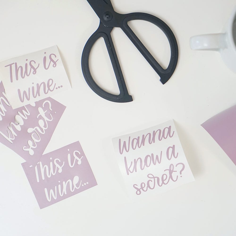 Lavender vinyl, black scissors, and white coffee cups on a white background for DIY wine mugs