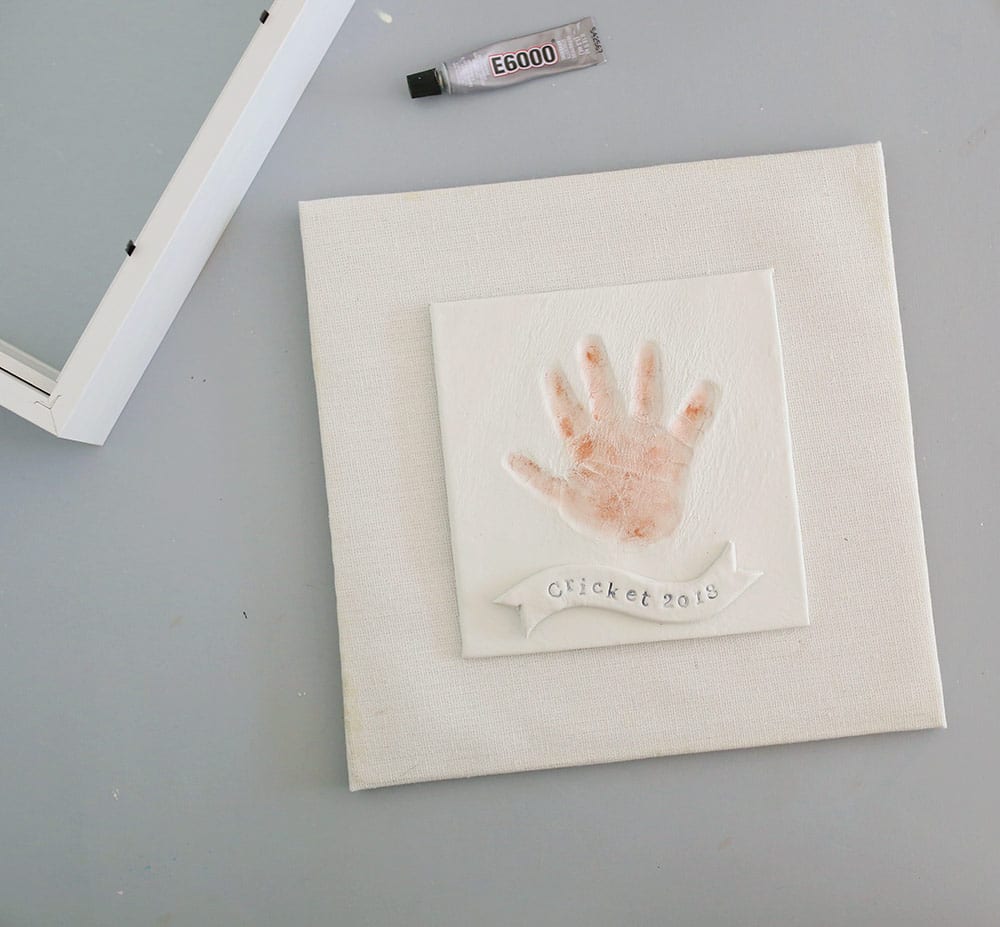 Copper hand print in air dry clay on a silicone baking mat to make a diy baby clay handprint keepsake frame