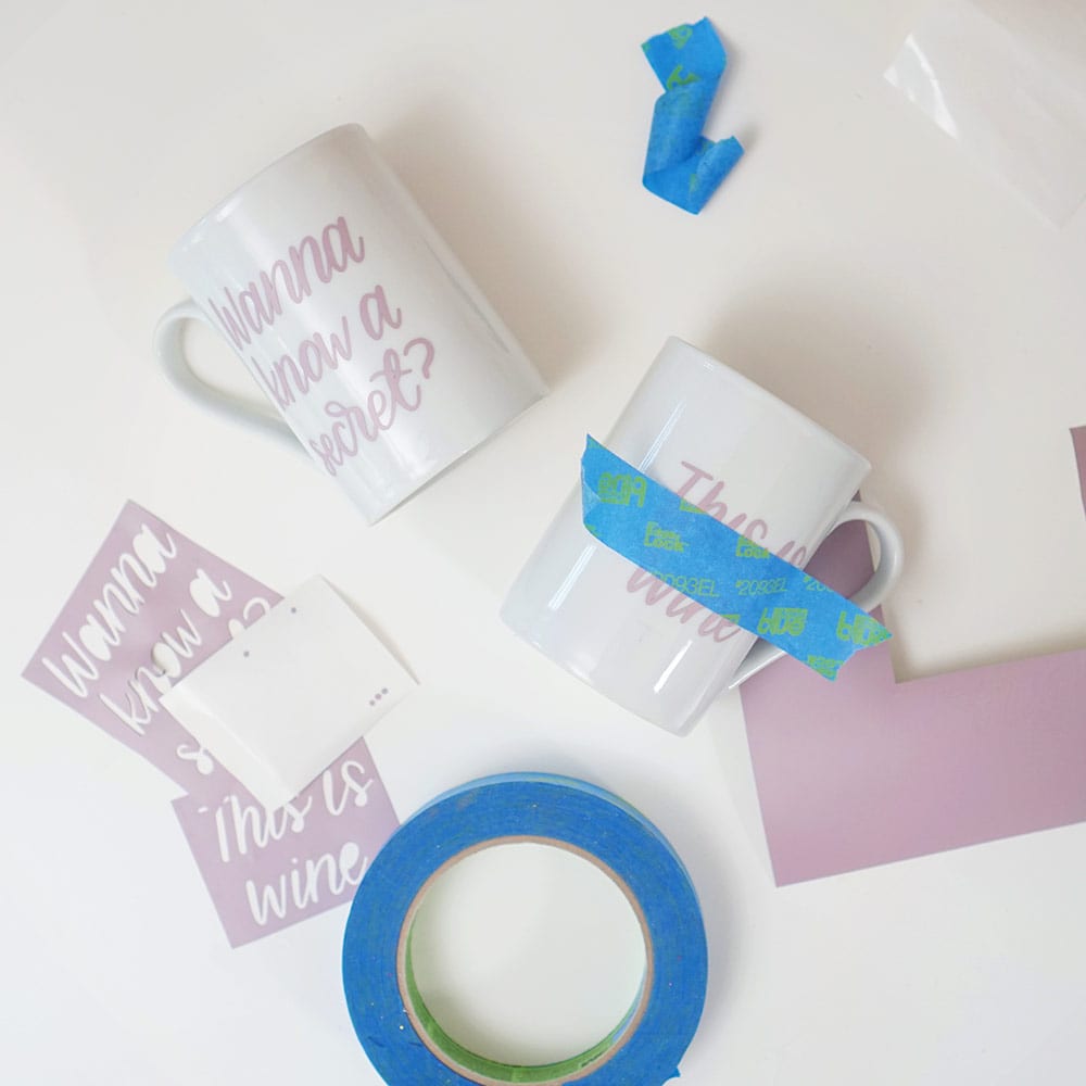 Lavender vinyl, blue tape, and white coffee cups on a white background for DIY wine mugs