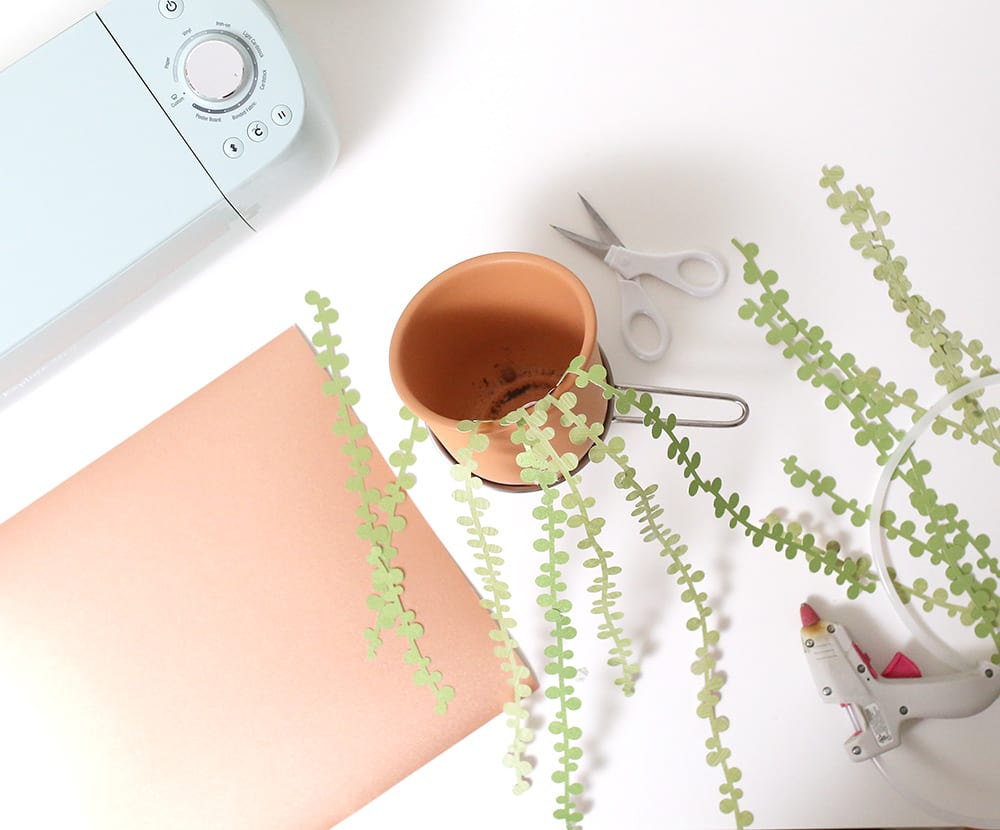 String of pearls DIY paper succulents in a terra cotta pot against a white wall