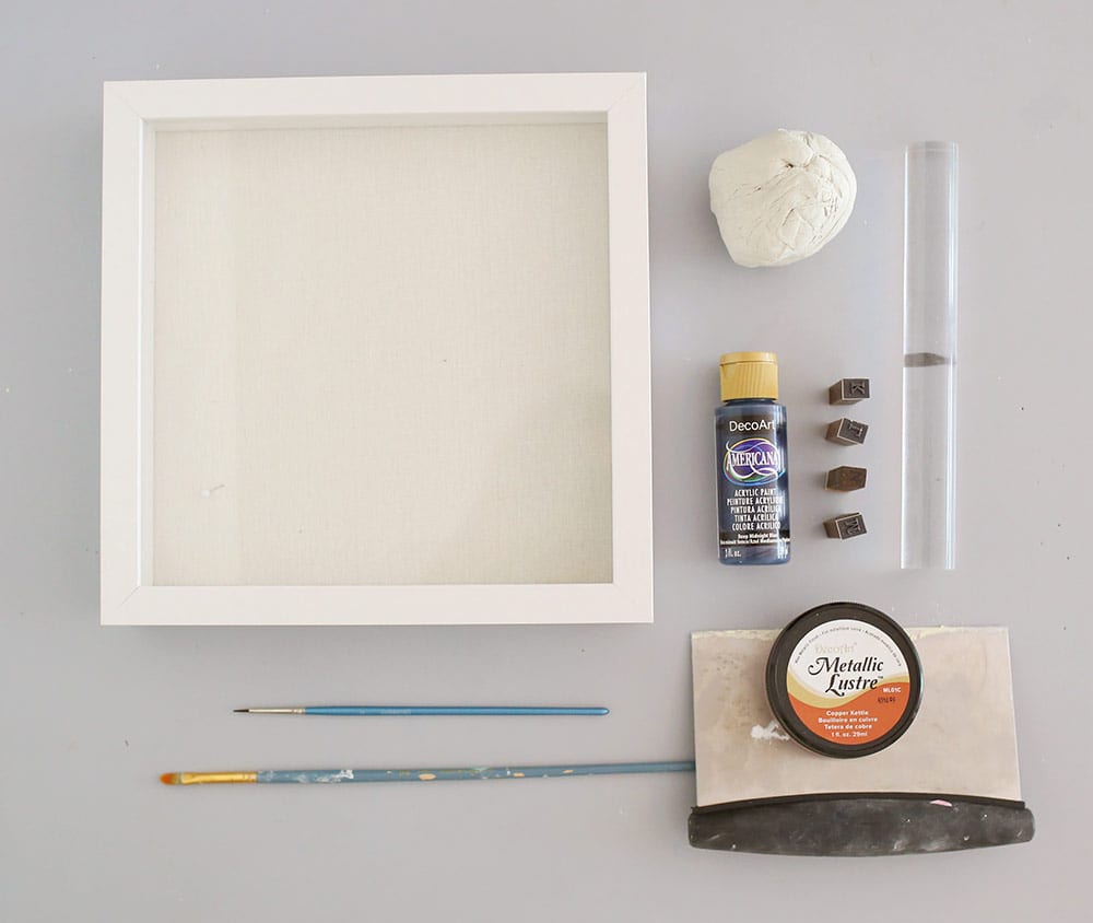 Supplies for an air dry clay on a silicone baking mat to make a diy baby clay handprint keepsake frame
