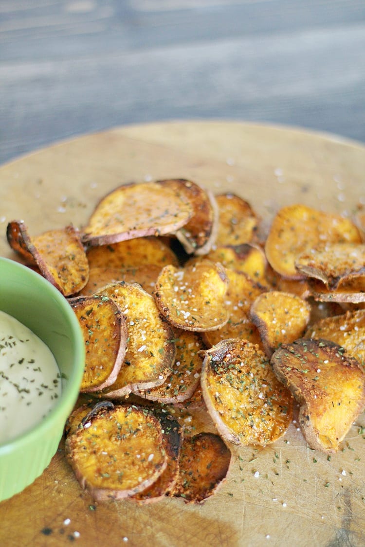 Organic Parmesan Herb Crispy Baked Sweet Potato Chips Recipe on a wooden serving board