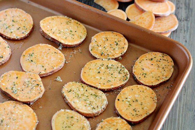 Parmesan Herb Crispy Baked Sweet Potato Chips Recipe spread out on a baking sheet