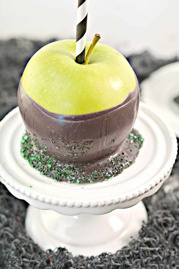 Green apples dipped in black chocolate to make poison apples for a Halloween party