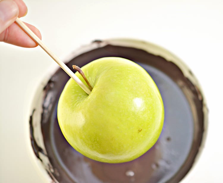 Green apples dipped in black chocolate to make poison apples for a Halloween party