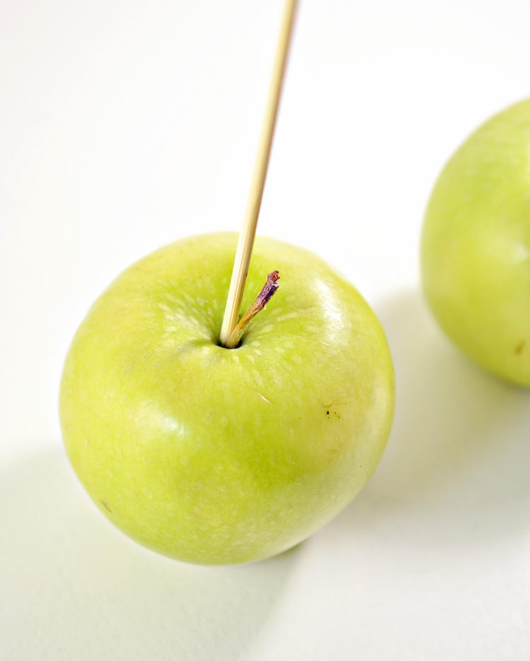 Green apples dipped in black chocolate to make poison apples for a Halloween party