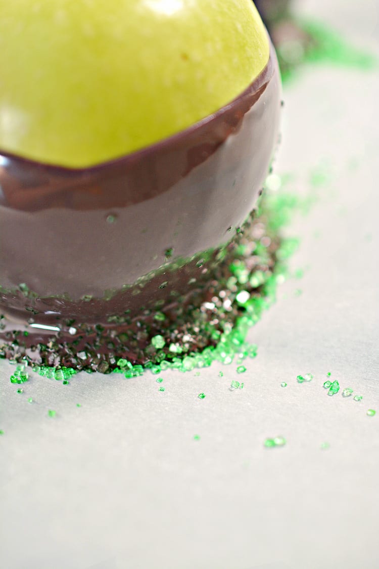 Green apples dipped in black chocolate to make poison apples for a Halloween party