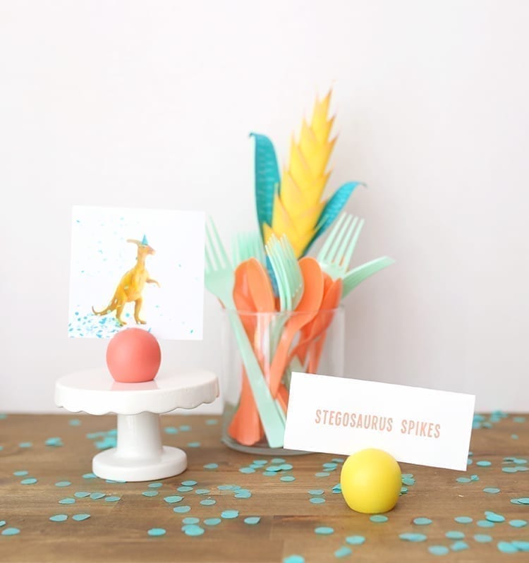 Dinosaur birthday party setup with yellow, coral, and teal accessories