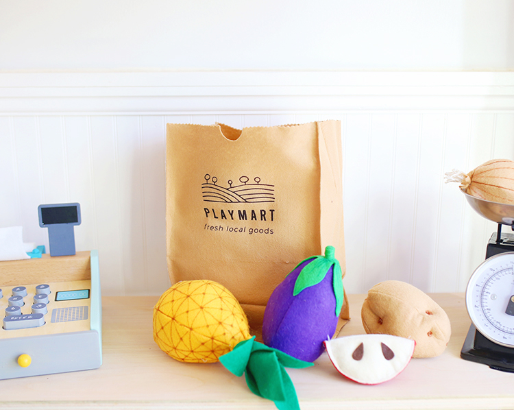 Felt fruit and vegetables and a DIY play grocery bag that looks like a brown paper bag