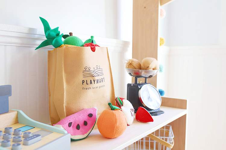 Felt fruit and vegetables and a DIY play grocery bag that looks like a brown paper bag